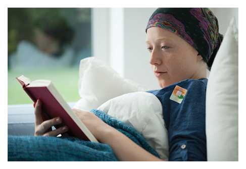 Cancer patient reading a book wearing Elequil Aromatabs aromatherapy